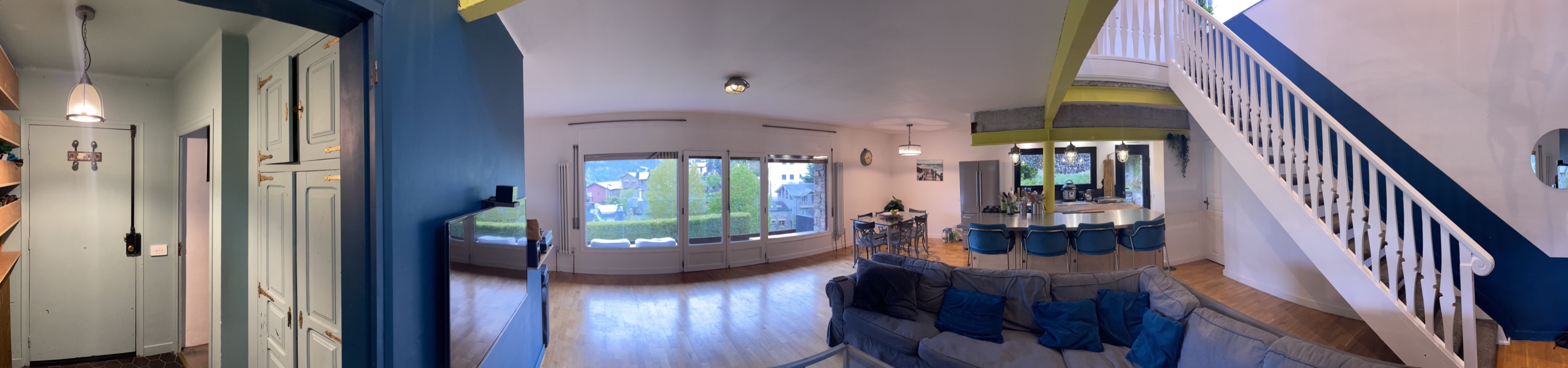 Panoramic view of living room, kitchen and staircase